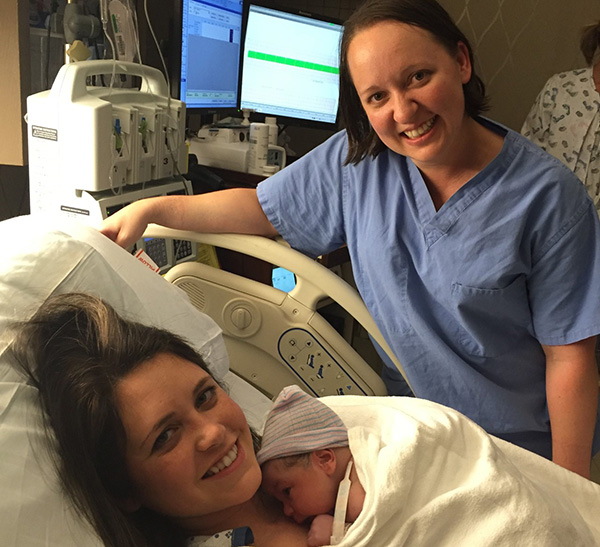 A patient smiles and holds her newborn baby delivered by Dr. Draper, VPFW OB/GYN