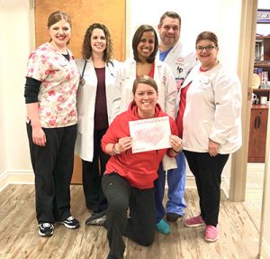 Dr. Clary and VPFW physicians and staff at VPFW's office at Henrico Doctors' Hospital wearing red accents with their white coats