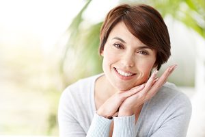 Woman in sweater smiling after October Special ThermiVa treatment