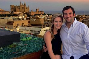 Dr. Caitlin Morin and her fiance smiling in front of the Spain skyline