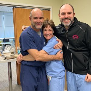 Dr. Mark Hyde celebrating his retirement from VPFW by hugging Dr. Leslie Davis and Dr. Stephen Pound