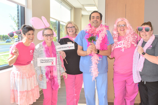 VPFW employees wearing pink and holding props during breast cancer awareness month to spread the word that mammograms save lives