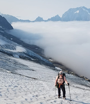 Dr. Jennie Draper mountain trekking above the clouds in snow