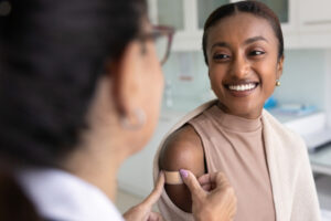smiling woman gets a bandaid after hormone blood test