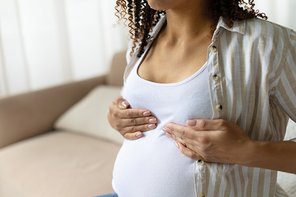 A pregnant woman touches her chest